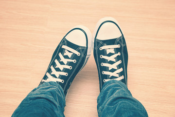sneakers with white laces and jeans close-up, vintage style