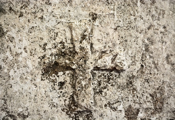 Ancient cross on the stone wall. Background