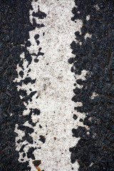 Strip of white paint on the asphalt road
