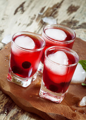 Red berry cocktail with mint and ice, selective focus