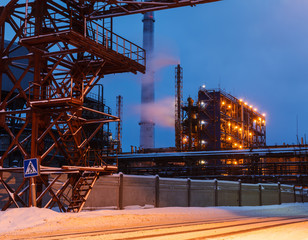 many pipes and smokestacks with industrial tower