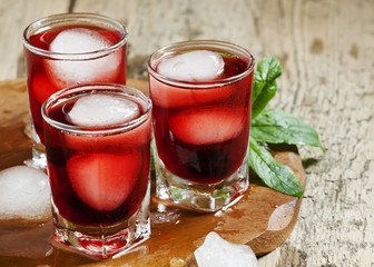 Red berry cocktail with mint and ice, selective focus