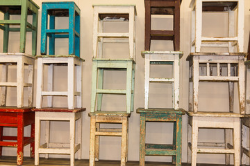 A bunch of worn and colorful stacked stools