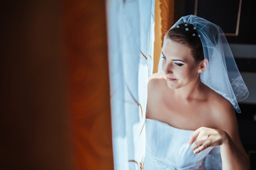 Fototapeta premium Bride getting ready. beautiful bride in white wedding dress with