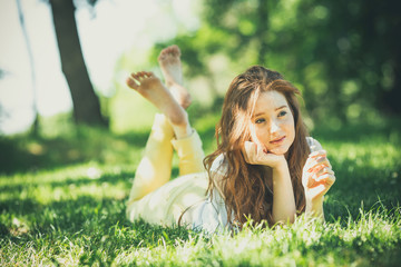 Beautiful red hair woman lying on grass at the park 