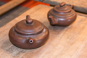 Two Traditional Brown Teapots on Wooden Table