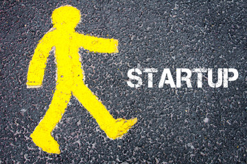 Yellow pedestrian figure walking towards STARTUP