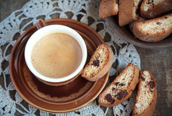 Cup of coffee and a handful of homemade biscotti with chocolate
