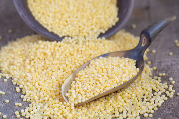 Dry Israeli couscous ptitim in a clay bowl and in the scoop on w