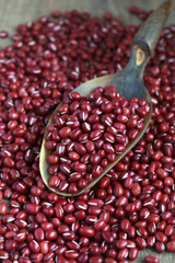 Dry red adzuki beans on wooden table, selective focus - some bea