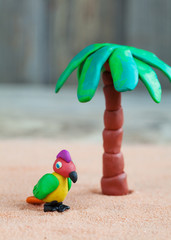 Plasticine world - little homemade multicolored parrot and palm