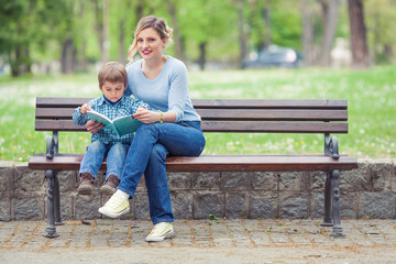 Fototapeta premium Little boy and his mother are reading a book 