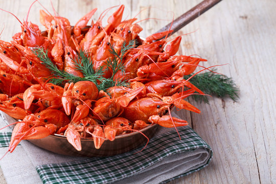 Copper Frying Pan With Red Boiled Crawfish On A Wooden Table