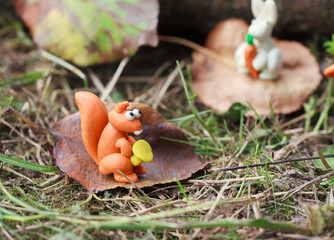 Plasticine world - small homemade squirrel holds the chanterelle