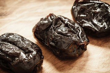 dried plums prunes on wooden table