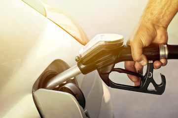 Close-up of a mens hand refilling the car with a gas pump