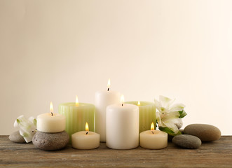 Fototapeta na wymiar Beautiful composition with candles and spa stones on light background