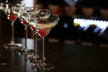 Glasses of cocktails on bar background