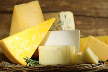 Different sort of cheese on wicker tray, closeup