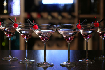 Glasses of cocktails on bar background