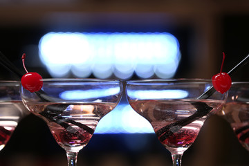 Glasses of cocktails on bar background