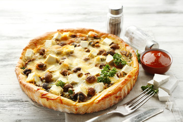 Cheese pie with mushrooms, herbs and sour creme, on wooden table background