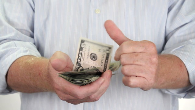 Man holding USA money in hands counts the dollars quickly.
