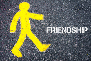 Yellow pedestrian figure walking towards FRIENDSHIP