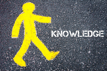 Yellow pedestrian figure walking towards KNOWLEDGE