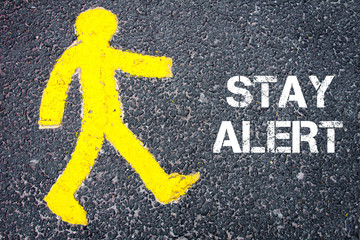 Yellow pedestrian figure walking towards STAY ALERT