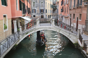 Fototapeta na wymiar Gondola on narrow canal in Venice, Italy