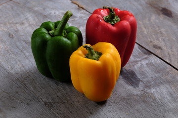 Colorful bell peppers on wooden table