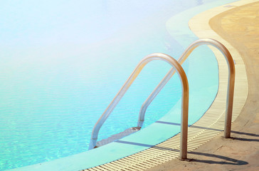Fototapeta na wymiar Swimming pool in curved shhape with stairs