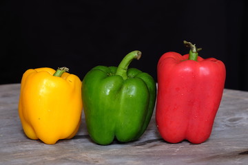 Colorful bell peppers on wooden table