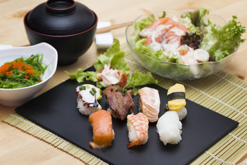 Sushi assortment on black dish, close up