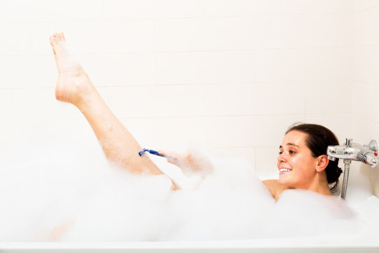 Woman Shaving Legs In Bath