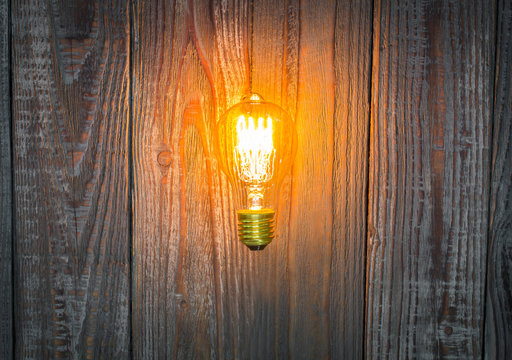 Glowing bulb on the wood background