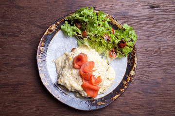 Scrambled egg and smoked salmon on wooden