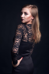 Fototapeta premium Woman in cocktail dress on black background