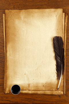old paper on brown wood texture with feather and ink.
