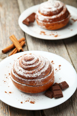 Cinnamon buns on plate on grey wooden background