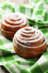 Freshly baked cinnamon buns on green napkin