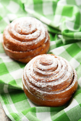 Freshly baked cinnamon buns on green napkin
