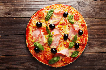 Delicious fresh pizza on brown wooden background