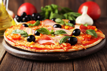 Delicious fresh pizza on brown wooden background