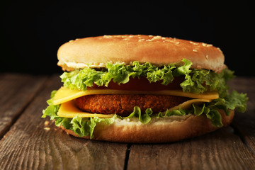 Big burger on brown wooden background