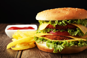 Big burger on brown wooden background