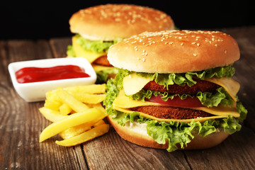 Big burgers on brown wooden background