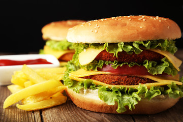 Big burgers on brown wooden background