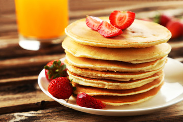 Delicious pancakes with strawberry on brown wooden background